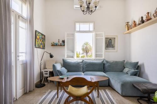 a living room with a blue couch and a table at Charming 2 BR Apt By The Foot Of The Bahai Temple in Haifa