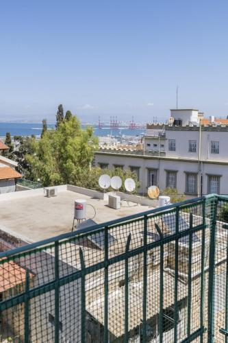 a balcony with a green fence and a building at Charming 2 BR Apt By The Foot Of The Bahai Temple in Haifa