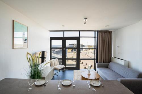 a living room with a couch and a table at Poort Beach Boutique Apartments in Bloemendaal Aan Zee