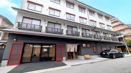 a building with red doors and a car parked in front at Kyoto Inn Gion in Kyoto