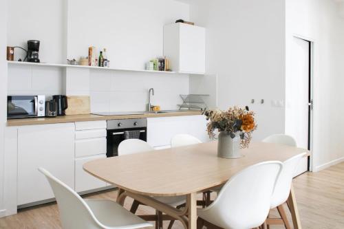 - une cuisine avec une table en bois et des chaises blanches dans l'établissement Bright 2bedrooms - Jardin des Plantes, à Paris