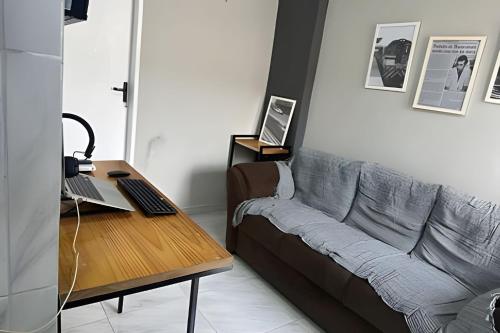 a living room with a couch and a desk with a laptop at Completa Perfeita para Turismo de Negócios e Lazer por Will Stay in Maracanaú