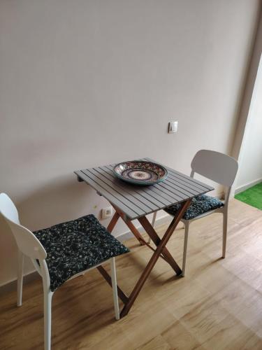 a table with two chairs and a plate on it at Chambre très propre avec salle de bain privée - 5 min airport casablanca in Nouaseur