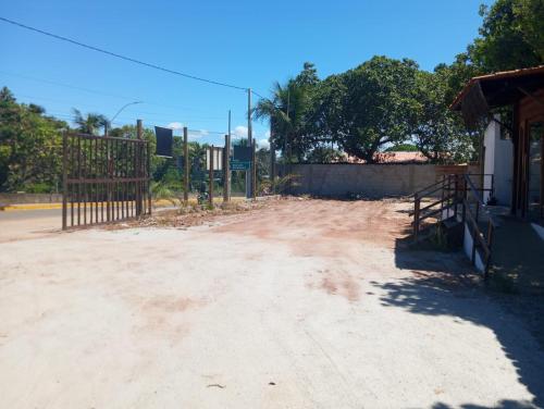 a dirt road with a gate in front of a building at Pipa Panorama Aparthotel in Pipa