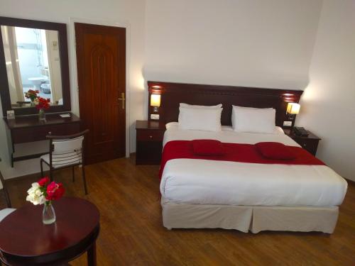 a hotel room with a large bed and a table at City Inn Palace Hotel in Ramallah