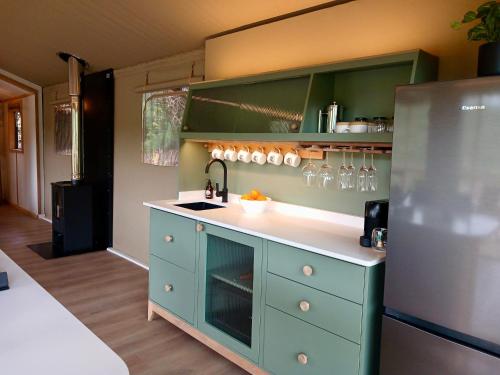 a kitchen with a sink and a refrigerator at AfriCamps Addo in Swanepoelskraal