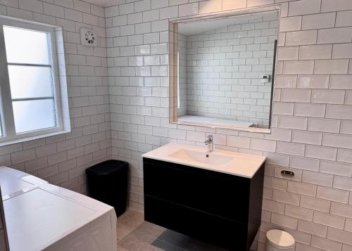 a white bathroom with a sink and a mirror at Newly renovated 2 bedroom apartment in Visby