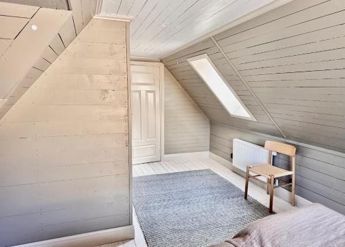a attic room with a staircase and a chair at Newly renovated 2 bedroom apartment in Visby