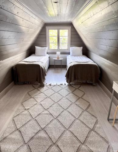 two beds in a small room in a log cabin at Newly renovated 2 bedroom apartment in Visby