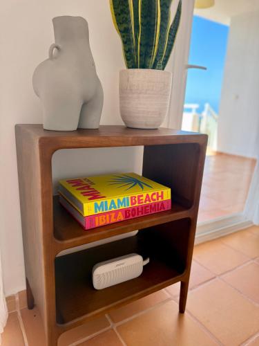 a book shelf with a potted plant and books at Casa Panorama in Illes Balears