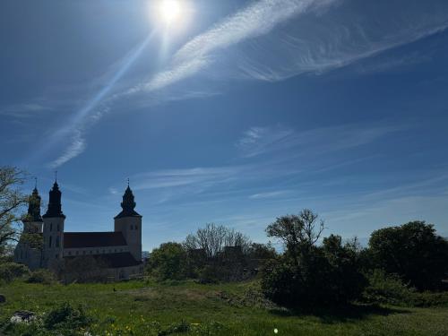 a church on a hill with the sun in the sky at Newly renovated 2 bedroom apartment in Visby