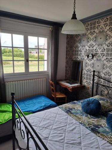 une chambre avec un lit, un bureau et une fenêtre dans l'établissement Au Coeur du Bocage Vendéen, à Chantonnay