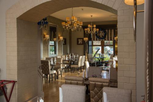 a dining room with tables and chairs and a chandelier at Errigal Country House Hotel in Cootehill