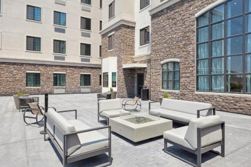 a patio with chairs and a coffee table in front of a building at Staybridge Suites Sacramento Woodland by IHG in Woodland