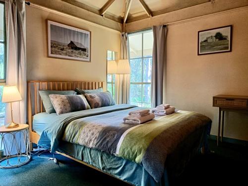a bedroom with a bed with towels on it at Kalimna Woods Cottages in Lakes Entrance