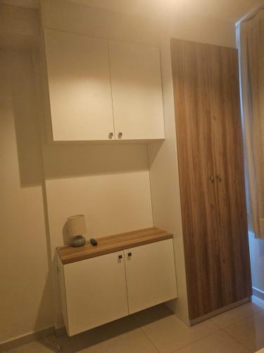 a kitchen with white cabinets and a wooden cabinet at Apto Aconchegante no coracao da Ilhotas in Teresina