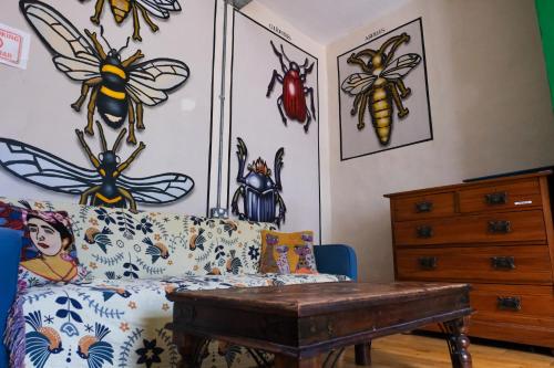 a living room with a couch and some bugs on the wall at The Full Moon Backpackers in Bristol