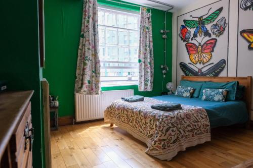 a bedroom with a bed and a window with butterflies on the wall at The Full Moon Backpackers in Bristol