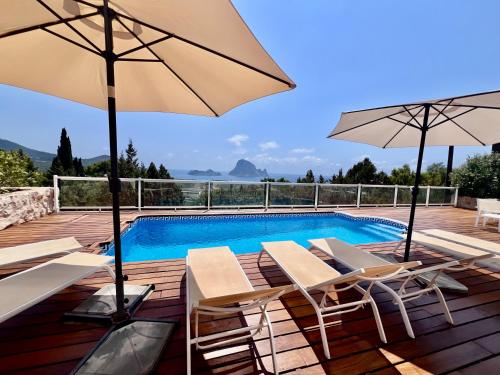 una piscina con sedie e ombrelloni su una terrazza di Casa Panorama a Illes Balears