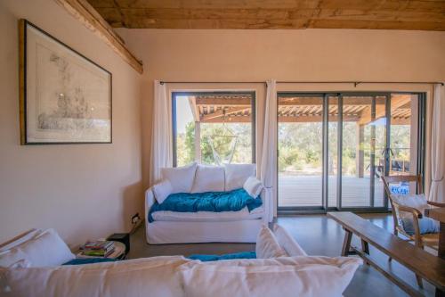 un soggiorno con un divano e una grande finestra di A Terra - Villa à 200m de la mer a Pianottoli-Caldarello