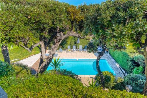 - une vue sur la piscine bordée d'arbres dans l'établissement Your Getaway in Biot, à Biot
