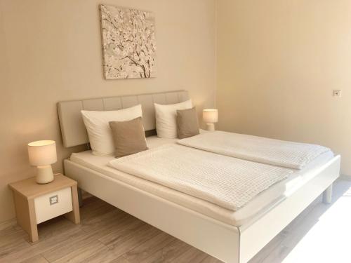 a white bed with white sheets and pillows at Gast und Weinhof Beim Schneemann in Valwig