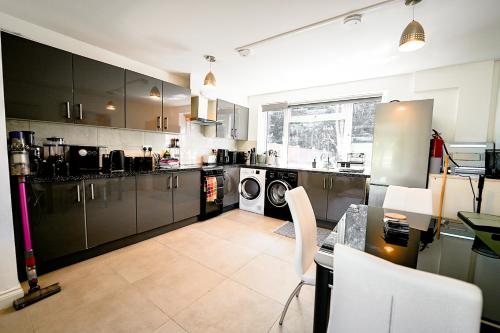 a kitchen with stainless steel appliances and a table at Cliveden Garden Cottage sleeps 6 - With Hot Tub, Parking, in Taplow - next to Cliveden National Park in Maidenhead