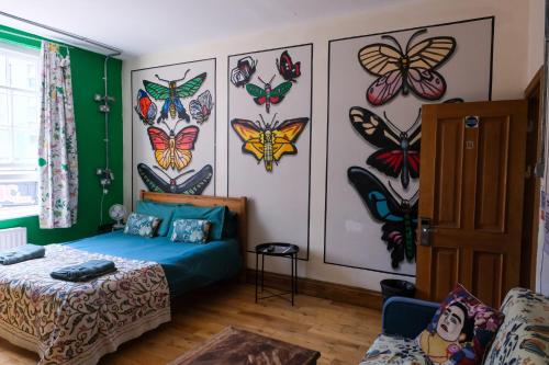 a bedroom with a bed and butterflies on the wall at The Full Moon Backpackers in Bristol
