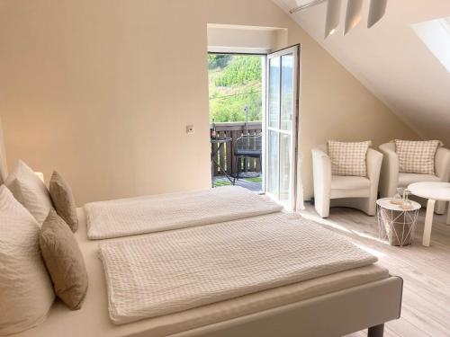 two beds in a room with a window at Gast und Weinhof Beim Schneemann in Valwig