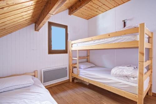 two bunk beds in a small room with a window at Chalet Sophie - Proche station de ski in Les Angles