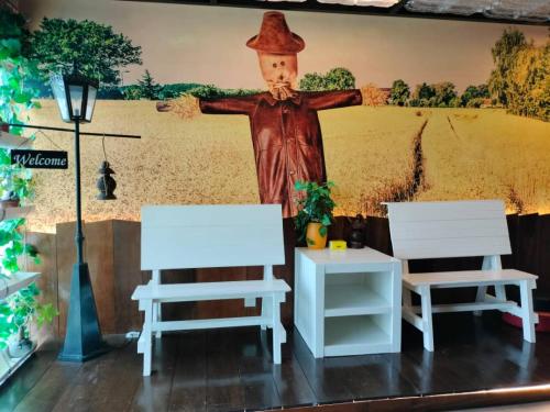 two white chairs and a painting of a cross at Sekinchan PaddyCruise Homestay Wifi in Sekincan
