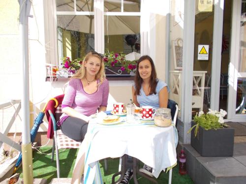 two women sitting at a table on a porch at Villa KONIG in Mariánské Lázně