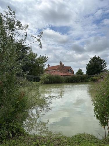 a house sitting next to a body of water at Foxglove in Thimbleby