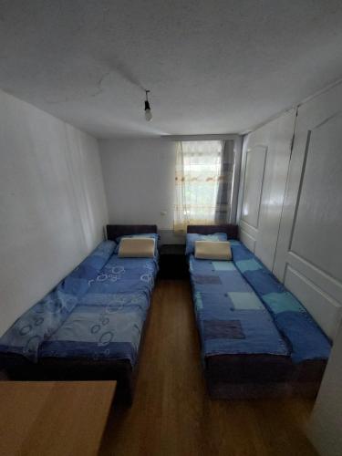 two beds in a small room with a window at Sobe za izdavanje Nedeljković in Lukovo