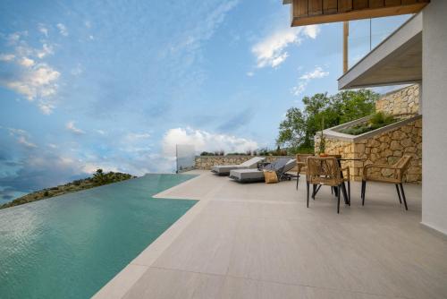 an outdoor patio with a view of the water at Anadeo Villas & Suites in Exanthia