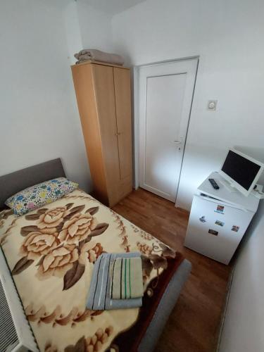 a small bedroom with a bed and a printer at Sobe za izdavanje Nedeljković in Lukovo