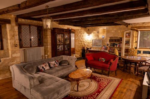 a living room with a couch and a table at Les Petits Cousins Du Québec - Chambres D’hôtes à Domme in Domme