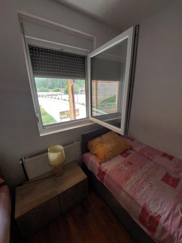 a small bedroom with a bed and a window at Sobe za izdavanje Nedeljković in Lukovo