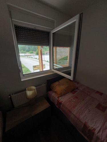 a small bedroom with a bed and a window at Sobe za izdavanje Nedeljković in Lukovo