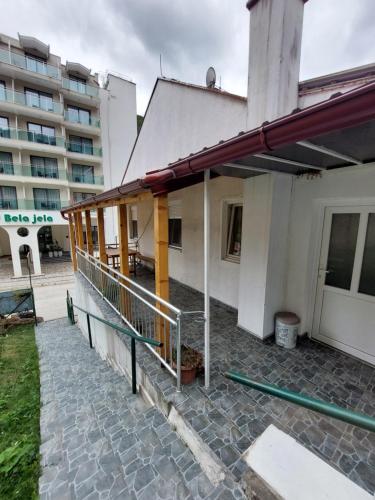 a building with a balcony and a building at Sobe za izdavanje Nedeljković in Lukovo