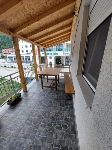 a patio with a wooden table on a balcony at Sobe za izdavanje Nedeljković in Lukovo