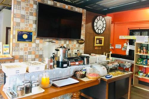 a kitchen with a counter and a clock on the wall at Chat House Chiang Rai in Chiang Rai