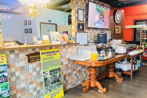 a coffee shop with a counter with a table in a room at Chat House Chiang Rai in Chiang Rai
