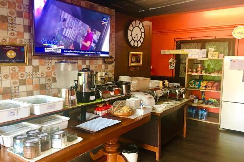 a kitchen with a counter and a tv in a room at Chat House Chiang Rai in Chiang Rai