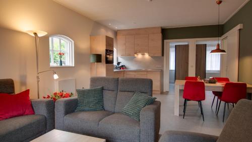 a living room and kitchen with a couch and a table at Vakantiehuisjes "De Veldzijde" in Losser