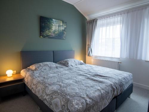a bedroom with a large bed and a window at Vakantiehuisjes "De Veldzijde" in Losser