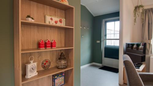 a room with green walls and a living room with a book shelf at Vakantiehuisjes "De Veldzijde" in Losser