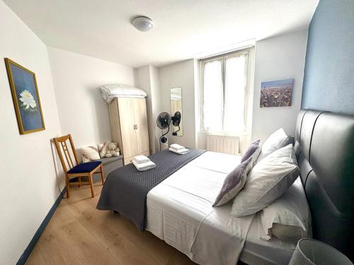 une chambre avec un lit, une chaise et une fenêtre dans l'établissement Chez Lucia appartement climatisé, à Périgueux