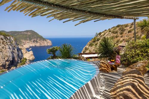a swimming pool with a view of the ocean at Hacienda Na Xamena, Ibiza in Na Xamena