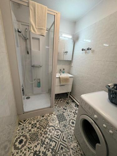 une salle de bain avec douche et machine à laver dans l'établissement Chez Lucia appartement climatisé, à Périgueux